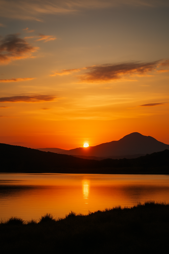 Coucher de soleil sans trépied sur un lac reflétant les montagnes